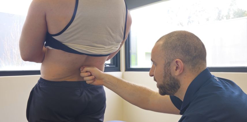 Physiotherapist assessing lower back movement and control at Adapt Sports Physiotherapy, Chirnside Park