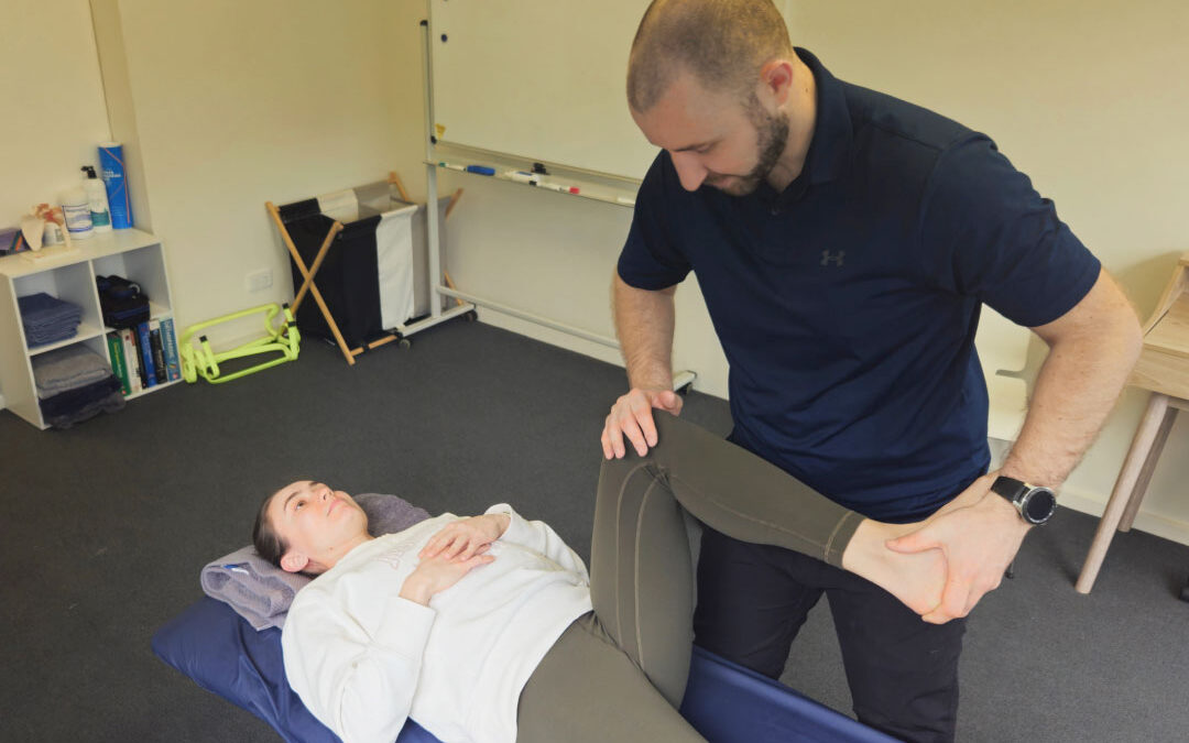 A physiotherapist examining a client's knee to assess the source of knee pain.