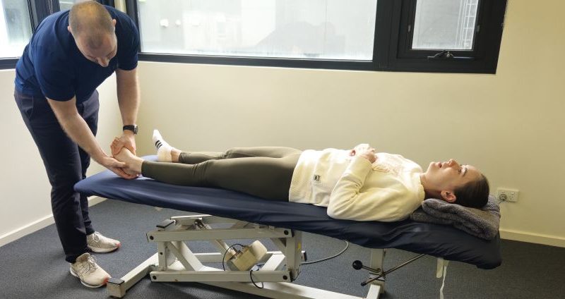 Physiotherapist assessing shin splints in a runner's lower leg